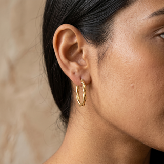 Model wearing 9K Yellow Gold Twist Oval Hoop Earrings - Sonny's Jewellers