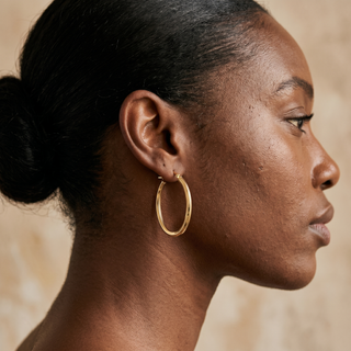 Model wearing 9K Yellow Gold Oval Hoop Creole Earrings - Sonny's Jewellers