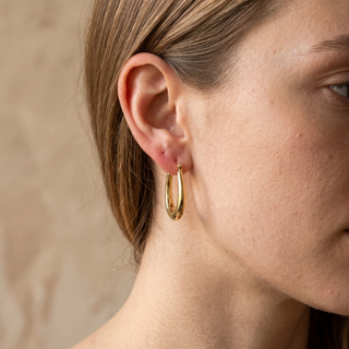 Model wearing 9K Yellow Gold Oval Creole Hoop Earrings - Sonny's Jewellers