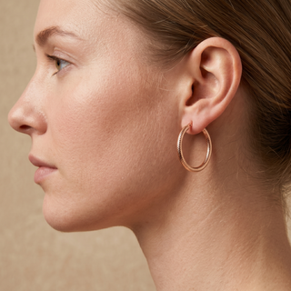 Model wearing 9K Rose Gold Medium Dimple Facet Hoop Earrings - Sonny's Jewellers