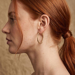 Model wearing 9K Yellow Gold Oval Hoop Earrings - Sonny's Jewellers