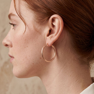 Model wearing 9K Rose Gold Dimple Facet Hoop Earrings - Sonny's Jewellers